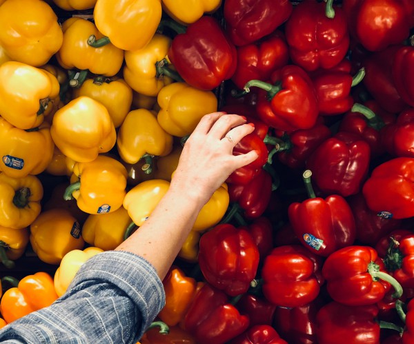 Person grocery shopping, bell peppers red and yellow