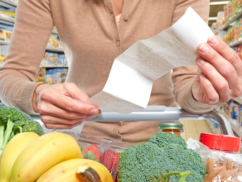 person exiting store with groceries and receipt